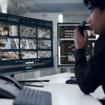 a man sitting at a desk with multiple monitors