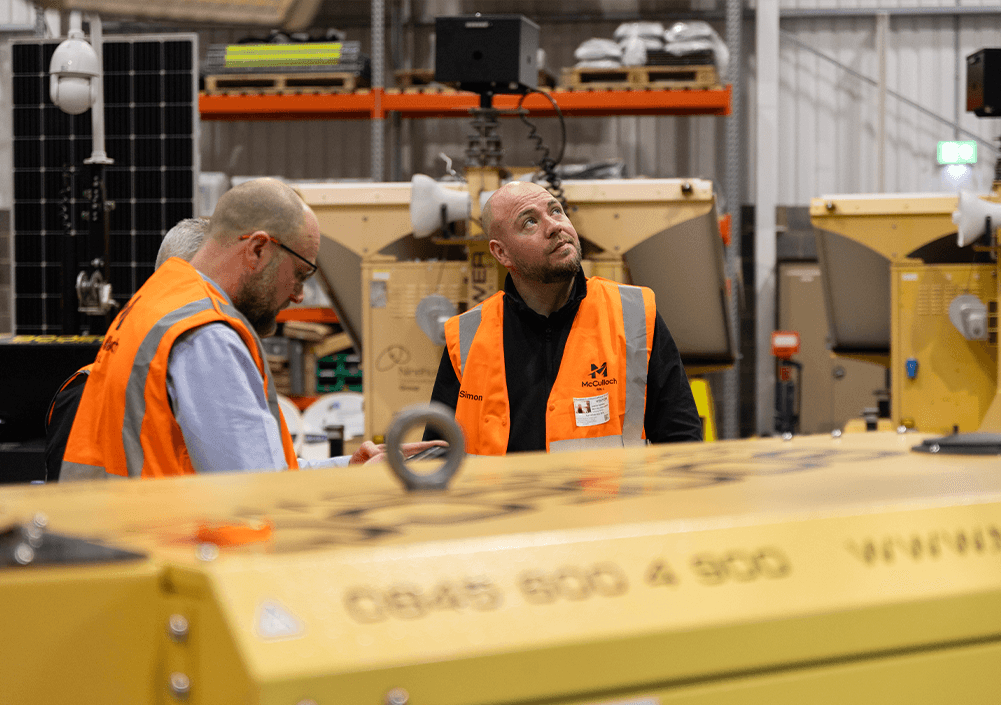 Two workers discussing in warehouse.