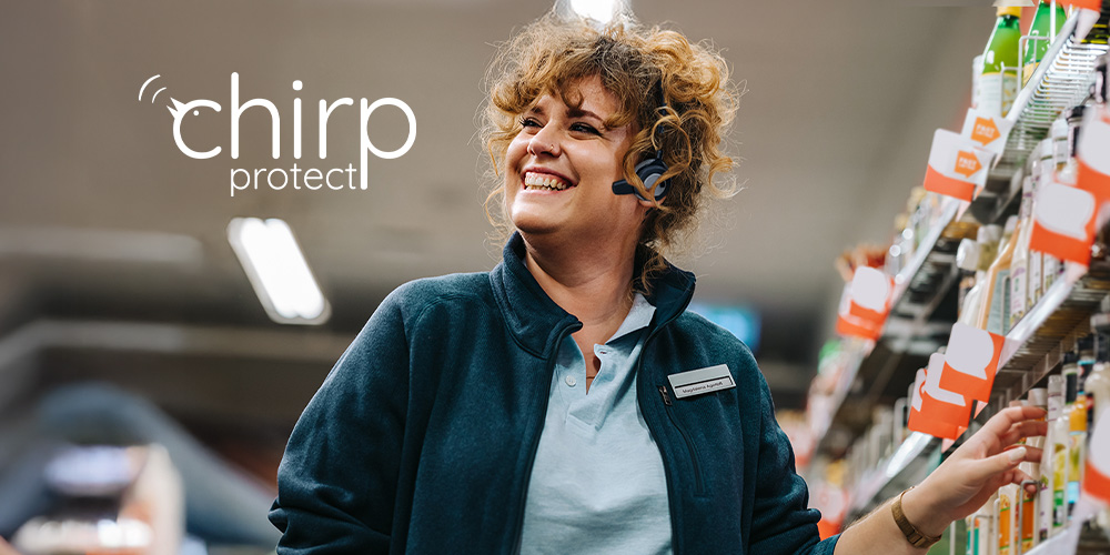 Smiling woman in supermarket aisle.