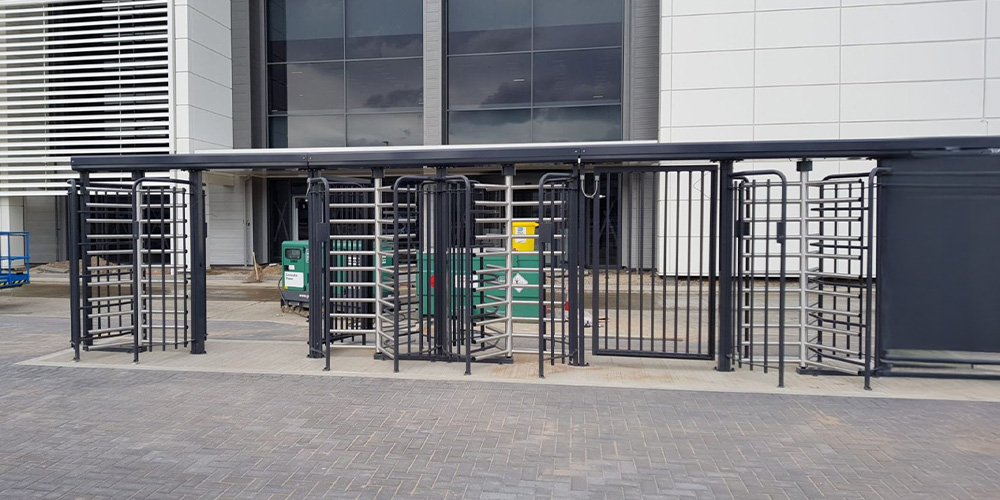 Metal turnstiles at building entrance.