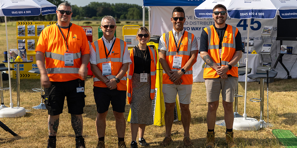 a group of people wearing orange vests and standing in front of a sign