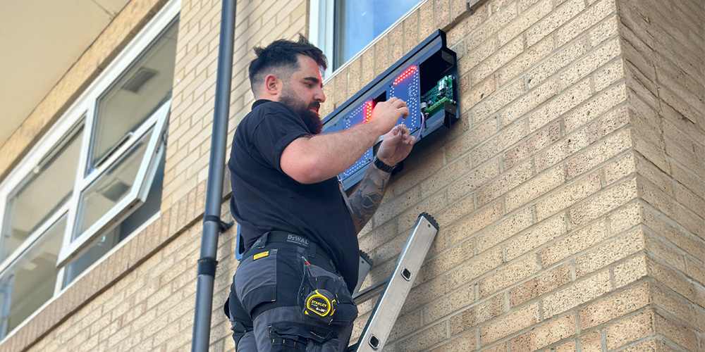 a man on a ladder working on a computer