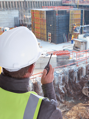 a man talking into a radio on a worksite