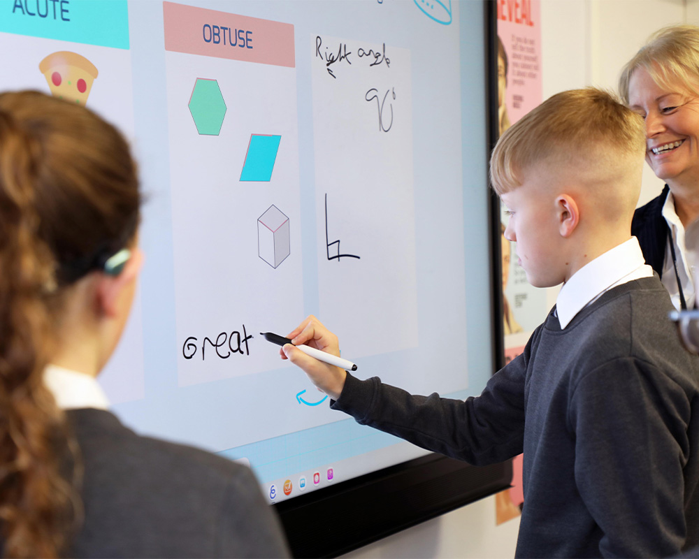 a boy writing on a interactive screen