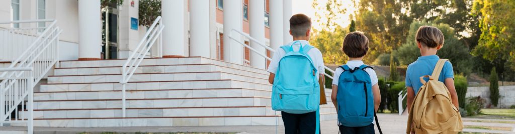 a child with a backpack walking up stairs