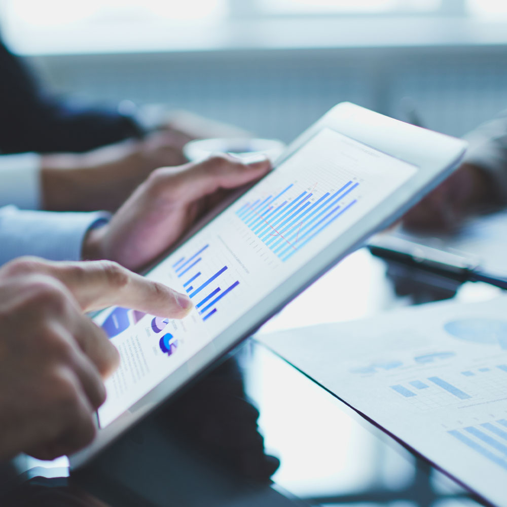 a womens hands using an ipad showing analytical data in a meeting