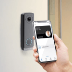 a hand holding a phone with a camera attached to a door